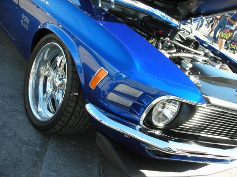 1998 Ford Crown Victoria - Close-up of a blue 1970 Ford Mustang Boss 302, showing its front quarter panel, wheel, and engine bay.