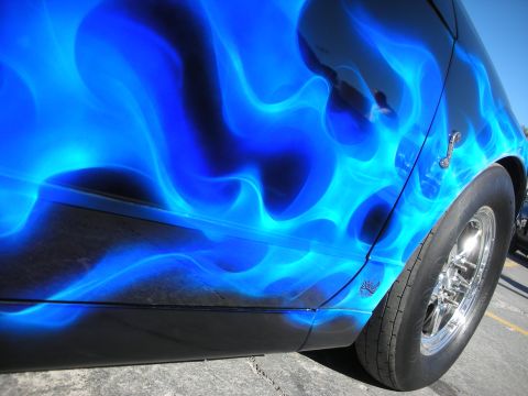 1998 Ford Crown Victoria - Side view of a car door with custom blue flame paint and a chrome wheel.