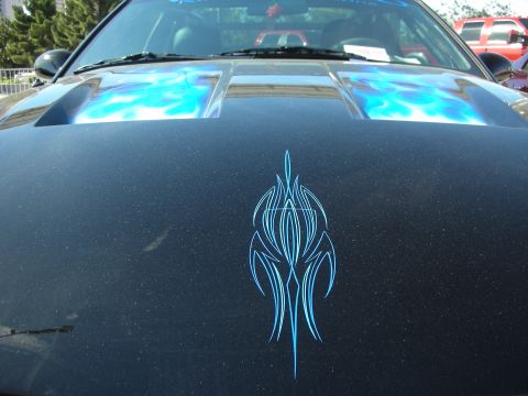 1998 Ford Crown Victoria - Customized black car hood features blue flame graphics and intricate pinstriping details.