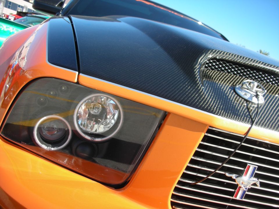Orange Ford Mustang with carbon fiber hood scoop and grille emblem
