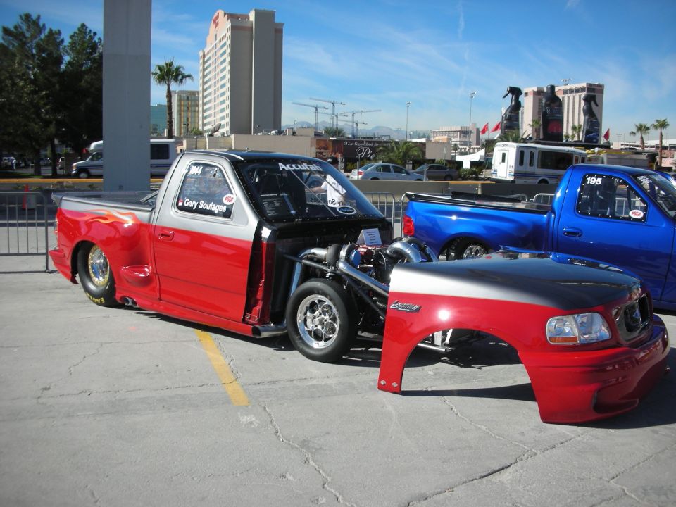 Red and silver pickup truck with exposed engine and detached front clip. 1998 Ford F-150