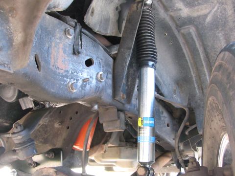 1996 Ford C-350 (Centurion Conversions) - Underneath view of a truck's suspension system, highlighting a shock absorber and frame components.