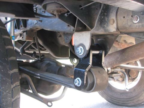 1996 Ford C-350 (Centurion Conversions) - Close-up view of a rear suspension leaf spring shackle assembly on a vehicle.