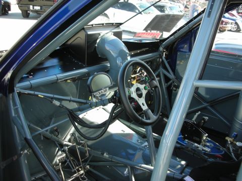 1998 Ford Crown Victoria - Custom racing interior features a roll cage, aftermarket steering wheel, and a digital display unit.