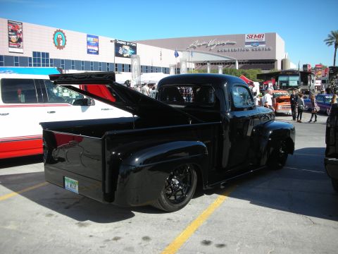 1998 Ford Crown Victoria - Custom black pickup truck seen at an outdoor event with other vehicles and buildings in the background.