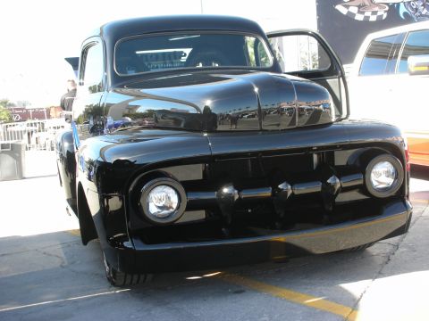 1998 Ford Crown Victoria - A shiny black pickup truck is parked outside with its door open.