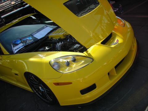 1998 Ford Crown Victoria - Front view of a yellow Chevrolet Corvette with its hood open, revealing the engine bay.