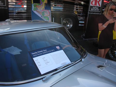 1998 Ford Crown Victoria - A sign on the windshield of a 1962 Ferrari 250GTO details its mileage, list price, and other specifications.