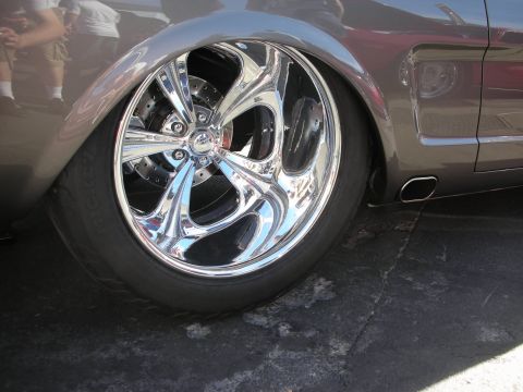 1998 Ford Crown Victoria - A highly customized classic car features a large, polished chrome wheel and low-profile tire.