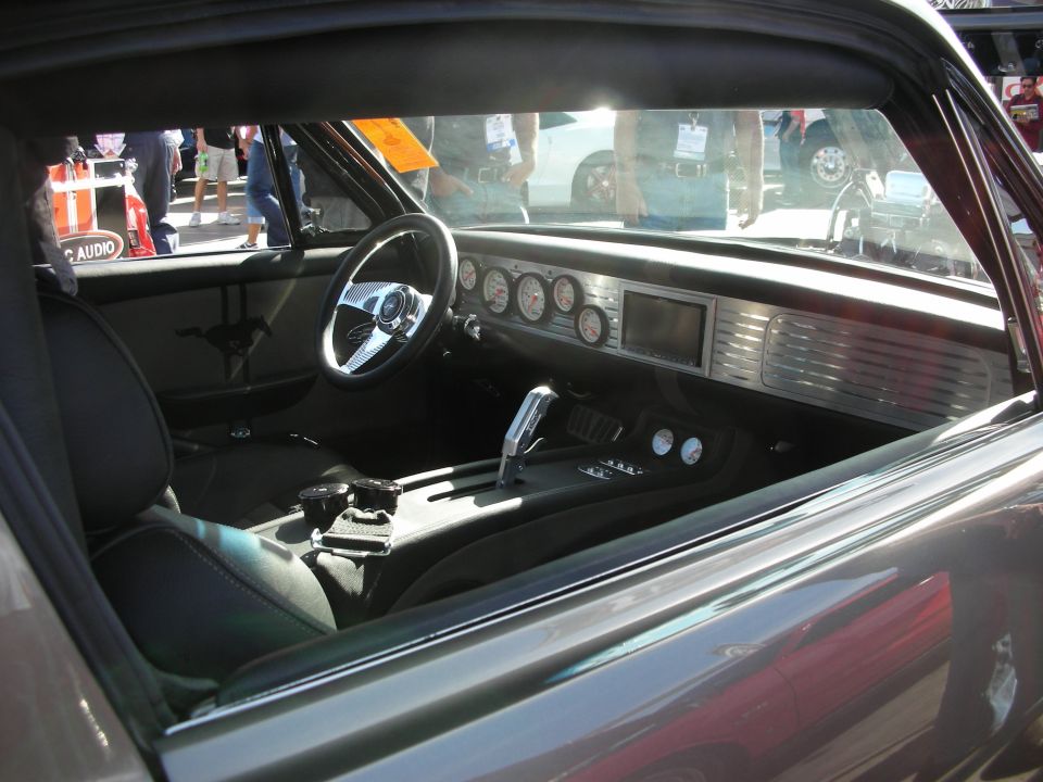 Car interior with custom dashboard, chrome steering wheel, and racing gauges