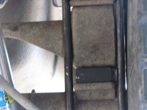 1996 Ford C-350 (Centurion Conversions) - A black bump stop is visible on the leaf spring assembly of a vehicle, likely for suspension dampening.