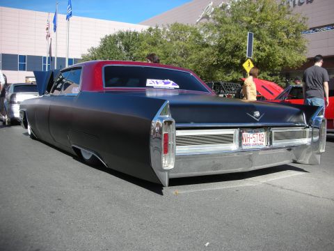 1998 Ford Crown Victoria - A classic Cadillac with a two-tone paint job and custom suspension sits parked on a street.