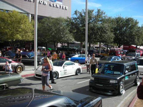 1998 Ford Crown Victoria - A black Scion xB with custom decals is parked at an outdoor event, with other vehicles and people around.