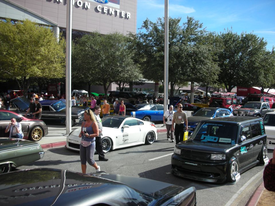 Black Scion xB with blue decals parked at an outdoor car show