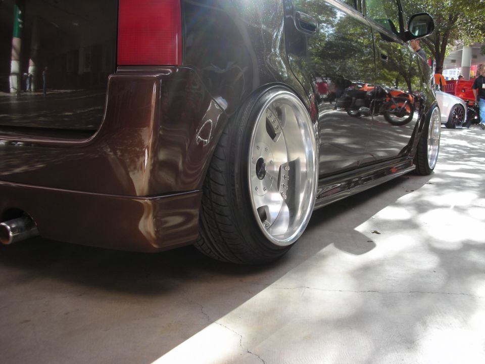Brown car with custom wheels and lowered suspension, side view