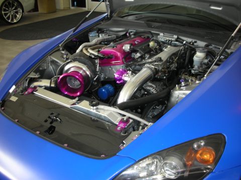 1998 Ford Crown Victoria - Customized engine bay a prominent turbocharger and vibrant purple components under the hood of a blue vehicle.