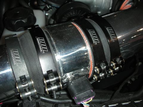 1998 Ford Crown Victoria - BDL Industries clamps secure a section of polished metal intake piping under the hood of a vehicle.