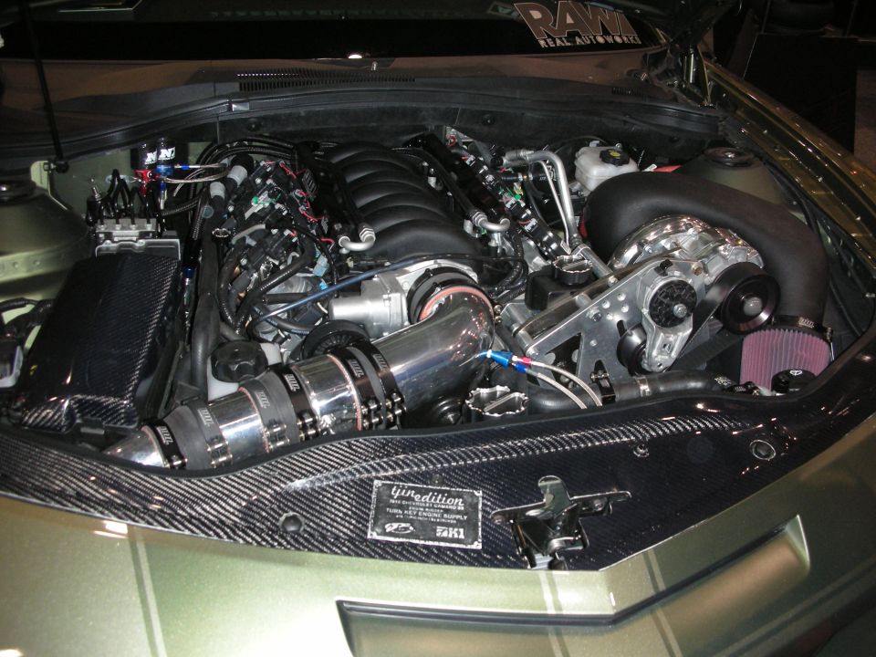Engine bay with a supercharger, custom intake, and carbon fiber accents