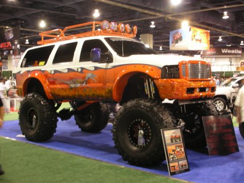 1998 Ford Crown Victoria - This heavily modified SUV features custom paint and oversized tires, displayed indoors.