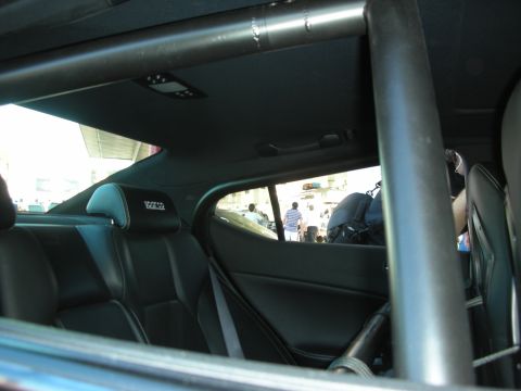 1998 Ford Crown Victoria - The interior of a car is visible, a roll cage and Sparco branded headrests.