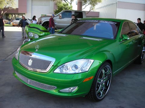 1998 Ford Crown Victoria - A bright green Mercedes-Benz S-Class sedan is parked outdoors, a distinctive custom grille and chrome wheels.