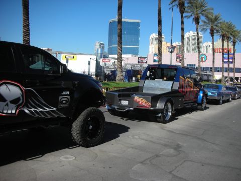 1998 Ford Crown Victoria - A custom flatbed truck with a unique paint job is parked in a line of vehicles on a sunny day.