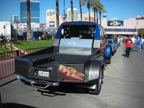 1998 Ford Crown Victoria - A custom pickup truck is parked on a street with buildings and palm trees in the background.
