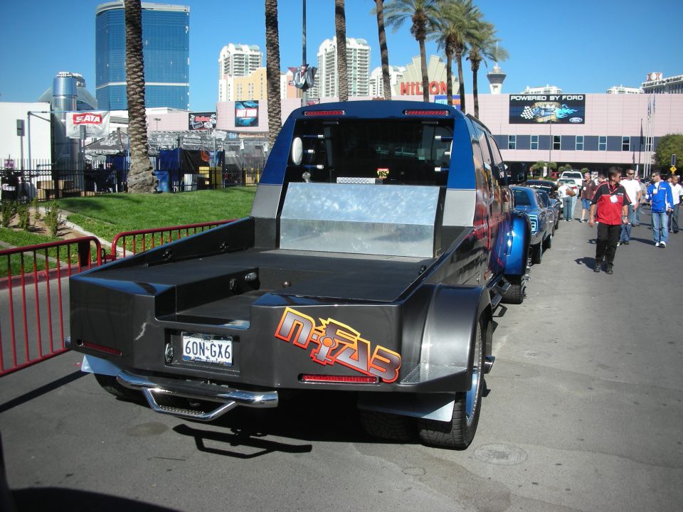 Custom pickup truck with dual rear wheels, flatbed, and custom graphics
