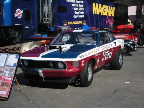 1998 Ford Crown Victoria - A custom Ford Mustang drag car is displayed with sponsor decals and a prominent hood scoop.