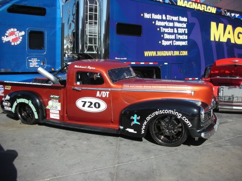 1998 Ford Crown Victoria - A custom hot rod pickup truck is parked in front of a large blue trailer with Magnaflow branding.