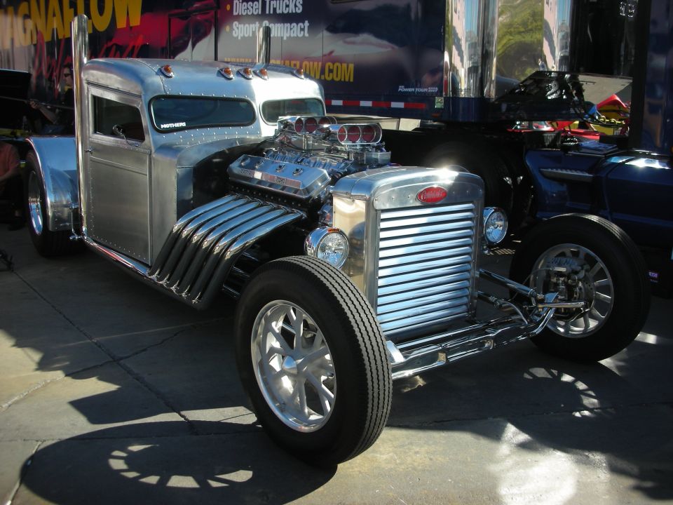 Chrome hot rod truck with exposed V8 engine and large exhaust pipes