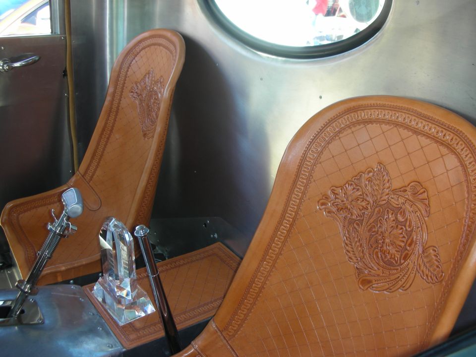 Close-up of two tan leather seats with intricate embossed designs and diamond stitching