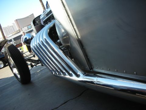 1998 Ford Crown Victoria - Close-up view of the shiny chrome exhaust pipes on the side of a silver custom vehicle.