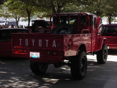 1998 Ford Crown Victoria - Rear view of a classic red Toyota pickup truck with a spare tire mounted in the bed.