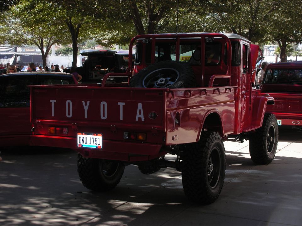 Red Toyota pickup truck, spare tire in bed, license plate DKU 1751