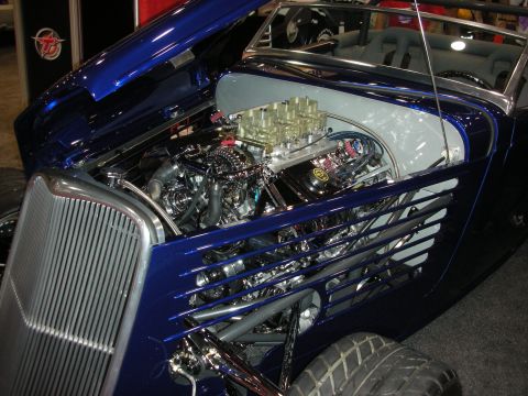 1998 Ford Crown Victoria - A custom hot rod is displayed with its hood open, revealing a powerful V8 engine and intricate details.