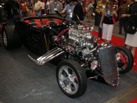 1998 Ford Crown Victoria - A custom hot rod with a prominent chrome engine and red interior is displayed indoors.