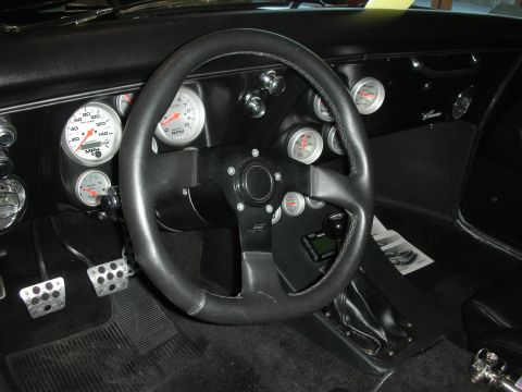 1998 Ford Crown Victoria - The dashboard features several aftermarket gauges, including a speedometer and tachometer, alongside a custom steering wheel.