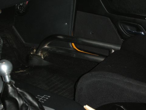 1998 Ford Crown Victoria - The interior of a car features a roll cage and a manual gear shifter with its pattern visible on the floor mat.