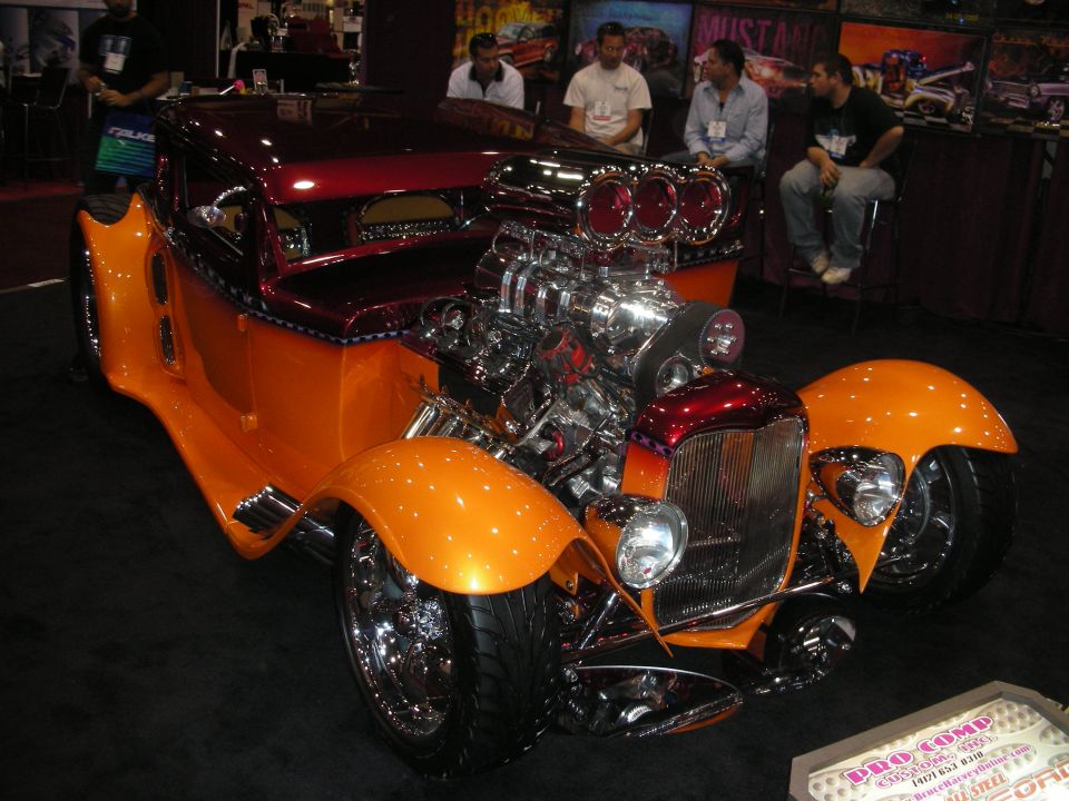 Orange and maroon custom hot rod with large supercharger and exposed engine