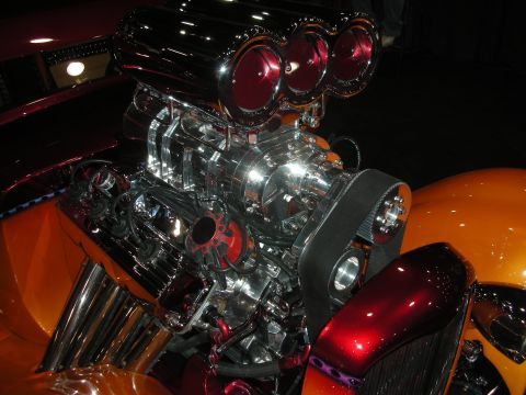 1998 Ford Crown Victoria - A highly polished engine with a prominent supercharger and vibrant orange and red bodywork is displayed.