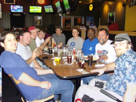 2007 Ford Mustang - A group of men are gathered around a table in a restaurant, enjoying drinks and conversation.