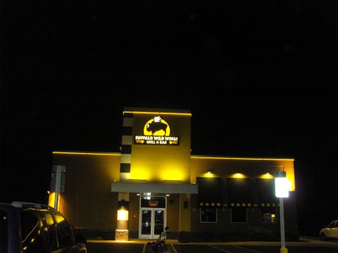 2007 Ford Mustang - Exterior view of a Buffalo Wild Wings restaurant at night, illuminated by yellow lights.