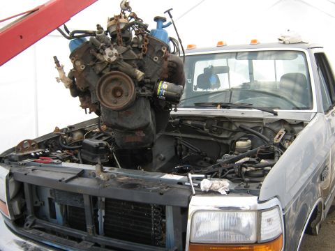 1992 Ford F-250 - The engine is being removed from the truck using an engine hoist.