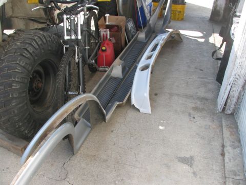 1996 Ford C-350 (Centurion Conversions) - Vehicle parts and a bicycle are stored on a concrete floor in what appears to be a garage or workshop.