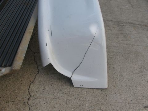 1996 Ford C-350 (Centurion Conversions) - A white fender flare shows a significant crack and some scratches.