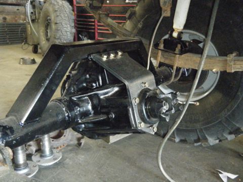 1978 Ford Bronco - Close-up view of a vehicle's rear axle and suspension system, aftermarket modifications. The Supermotors.net logo is visible in the lower r…