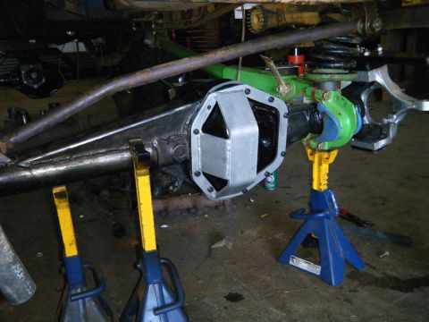 1978 Ford Bronco - Vehicle axle with an aftermarket differential cover, undergoing work and supported by jack stands.