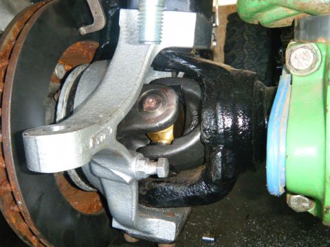 1978 Ford Bronco - Close-up view of a front axle U-joint and brake assembly, showing a rusty rotor and various metal components.