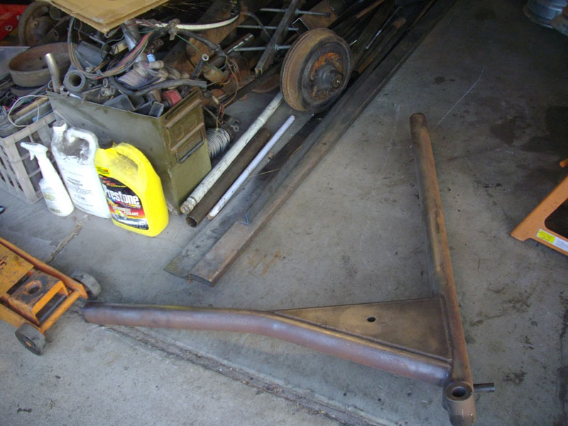 Rusty metal part on concrete floor with a yellow jug and white bottle